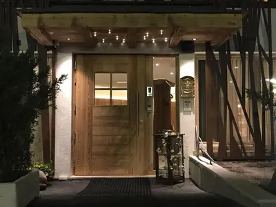 a wooden front door of a house with lights on it at Hotel Al Forte in Arabba