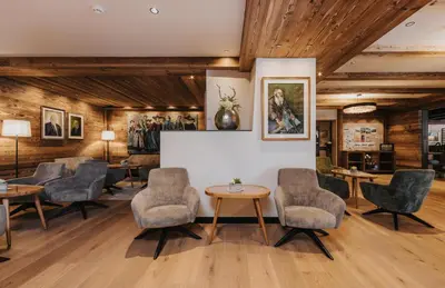 a waiting room with chairs and tables at Vitalhotel Dosses in Santa Cristina in Val Gardena