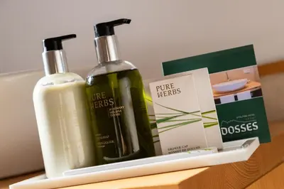 two bottles of soap and a box on a shelf at Vitalhotel Dosses in Santa Cristina in Val Gardena