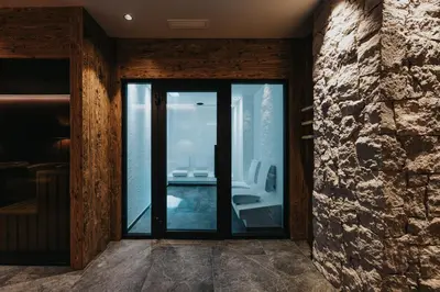 a bathroom with a glass door with a view at Vitalhotel Dosses in Santa Cristina in Val Gardena