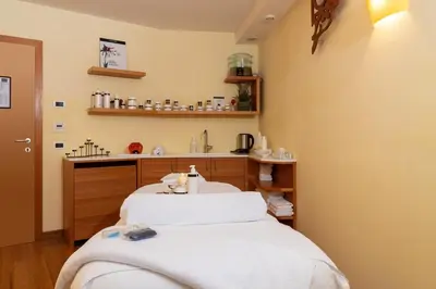 a therapy room with two beds and a sink at Vitalhotel Dosses in Santa Cristina in Val Gardena