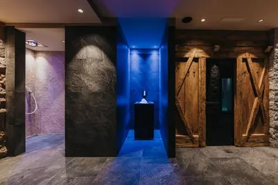 a hallway with blue lighting and wooden doors at Vitalhotel Dosses in Santa Cristina in Val Gardena