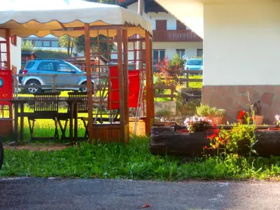a green yard with a house in the background at Hotel Orsa Maggiore in Falcade