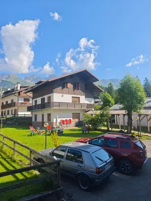 a view from the balcony of a building with a green field at Hotel Orsa Maggiore in Falcade