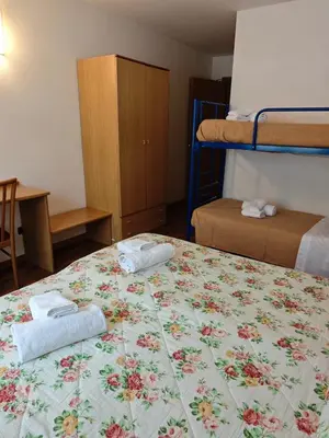 a bedroom with a bed with two towels on it at Hotel Orsa Maggiore in Falcade
