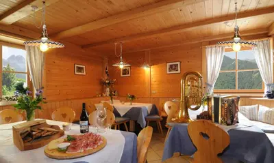 a dining room with two tables and a plate of food at Hotel Kompatscherhof in Luson