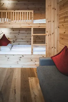 a room with two bunk beds and a couch at Hotel Kompatscherhof in Luson