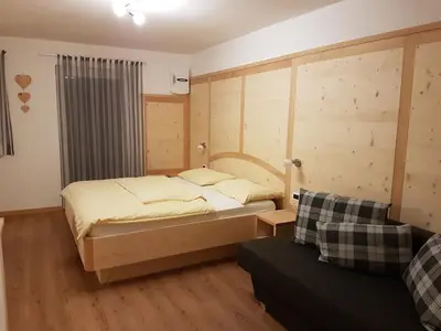 a bedroom with a bed and a couch at Villa Hubertus in Ortisei
