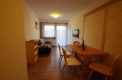 a living room with a dining room table and chairs at Villa Hubertus in Ortisei