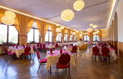 a banquet hall with tables and chairs and chandeliers at Hotel Salegg in Siusi