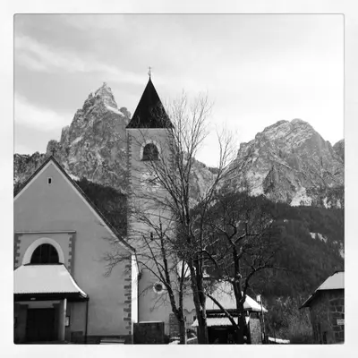 a church with a mountain in the background at Hotel Salegg in Siusi