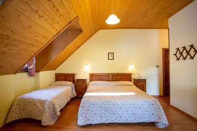 two beds in a bedroom with wooden ceilings at Hotel Salegg in Siusi