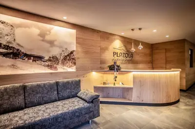 a sauna with wooden walls and benches in it at Luxury Chalet Plazola in Selva di Val Gardena