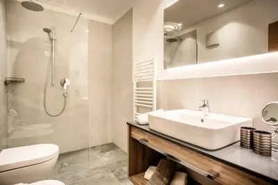 a bathroom with a sink and a toilet and a shower at Luxury Chalet Plazola in Selva di Val Gardena