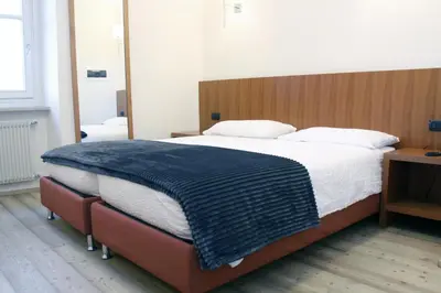 a bedroom with a bed with a blue blanket on it at Antica Trattoria in Cles