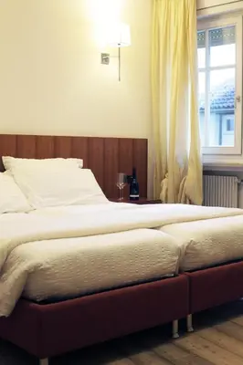 a bedroom with a large bed with a window at Antica Trattoria in Cles