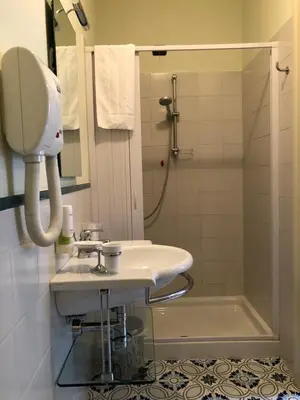 a white bathroom with a sink and a shower at Antica Trattoria in Cles