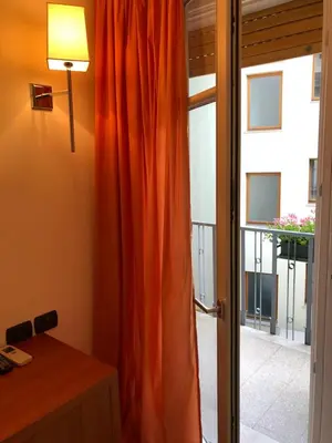 an orange curtain in a room with a window at Antica Trattoria in Cles