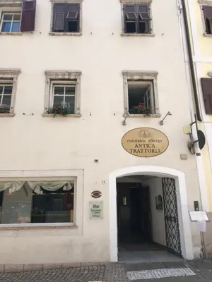 a white building with a sign on the side of it at Antica Trattoria in Cles