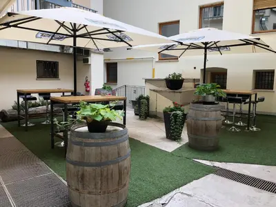 a patio with two tables and two umbrellas at Antica Trattoria in Cles