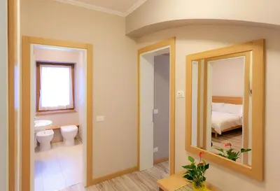 a bathroom with a toilet and a sink and a mirror at Appartamenti Regina in Alleghe
