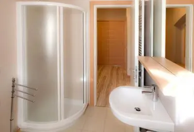 a white bathroom with a shower and a sink at Appartamenti Regina in Alleghe