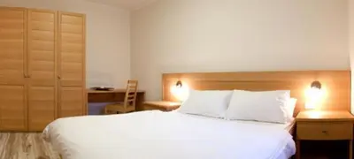 a bedroom with a large white bed with two pillows at Appartamenti Regina in Alleghe