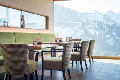a restaurant with tables and chairs and a large window at Berghotel Schlemmer in Bressanone