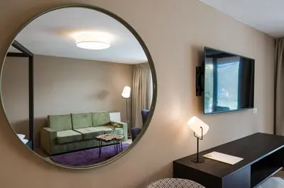 a living room with a couch and a chair and a table at Oliven- & Genusshotel Hirzer in Schenna