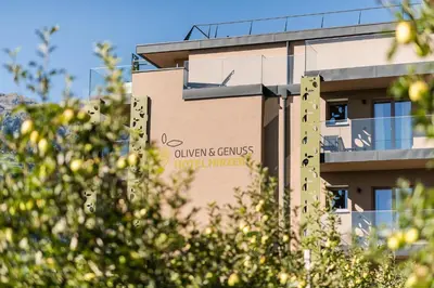 a building with a sign on the side of it at Oliven- & Genusshotel Hirzer in Schenna
