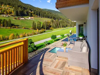 a house with a balcony on a green lawn at Apartment Spieglhof-2 by Interhome in Sarntal