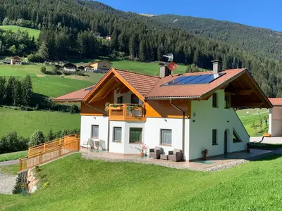 a house with a solar roof on a green field at Apartment Spieglhof-1 by Interhome in Sarntal