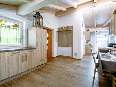 a kitchen with wooden cabinets and a dining room with a table at Apartment Spieglhof-3 by Interhome in Sarntal