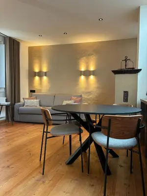 a living room with a table and chairs and a couch at ADAM Suites - Brixen Card included in Bressanone