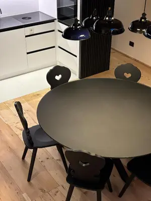 a black table and chairs in a kitchen at ADAM Suites - Brixen Card included in Bressanone