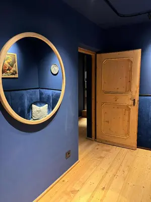 a room with a round mirror on a blue wall at ADAM Suites - Brixen Card included in Bressanone