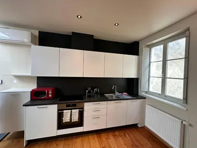 a kitchen with white cabinets and a red microwave at ADAM Suites - Brixen Card included in Bressanone