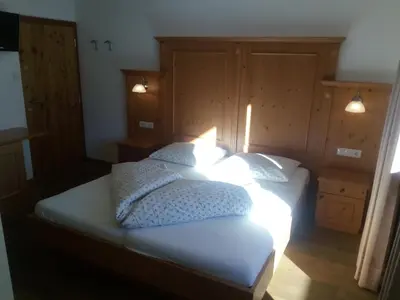 a bedroom with a bed with white sheets and pillows at Chalet Rasteck in Campo Tures