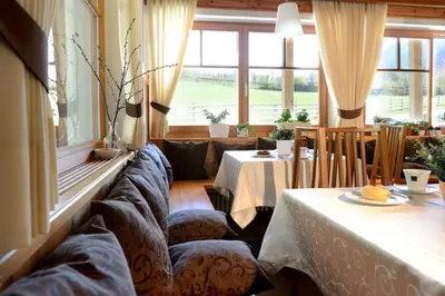 a room with chairs and a table and windows at Chalet Rasteck in Campo Tures