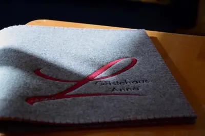 a piece of cloth with a red ribbon on it at Gästehaus Anna in Caldaro