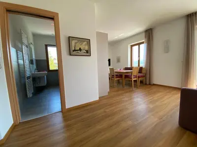 a living room with a table and a dining room at Gästehaus Anna in Caldaro
