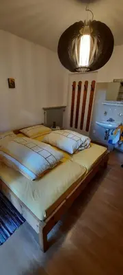 two beds in a bedroom with a chandelier at Hof am Brunnen in Cornaiano