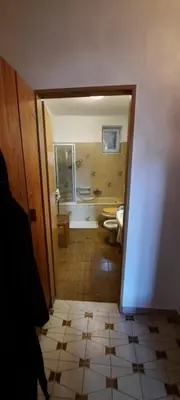 a bathroom with two toilets and a hallway with a doorway at Hof am Brunnen in Cornaiano