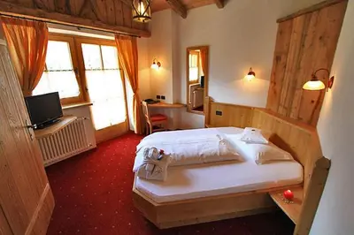 a bedroom with a large bed in a room at Hotel Garni San Nicolò in Pozza di Fassa