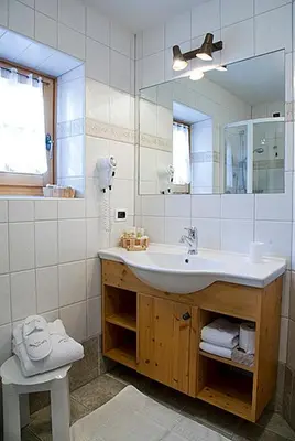 a bathroom with a sink and a mirror at Hotel Garni San Nicolò in Pozza di Fassa