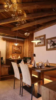 a dining room with a wooden table and chairs at Hotel Garni San Nicolò in Pozza di Fassa