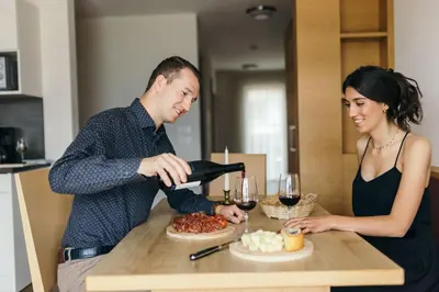 a woman pouring a man a glass of wine at Apartment Ruprecht in Tirolo