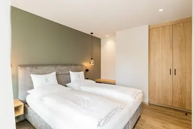 a bedroom with two beds with white sheets at Apartment Ruprecht in Tirolo
