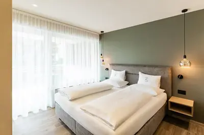 two beds in a bedroom with a large window at Apartment Ruprecht in Tirolo