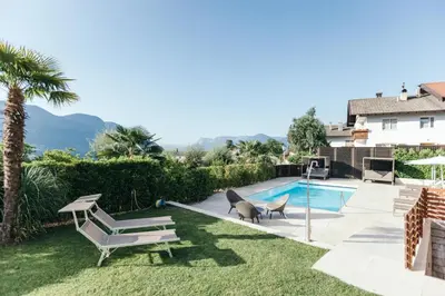 a backyard with a swimming pool and a house at Apartment Ruprecht in Tirolo